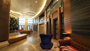 A spacious lobby with a curved ceiling, modern seating, and a large window providing a view of the outdoors.