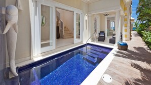A swimming pool with a glass bottom, a stone sculpture, and a covered outdoor seating area with a view of the ocean. - Stylish Beachfront Villa with Plunge Pool - Still Fathoms (4 bed) (Reeds Bay)