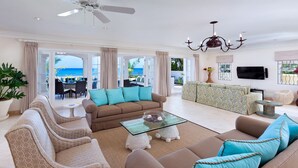 A spacious living area with a sofa set, a glass coffee table, and a view of the beach. - Stylish Beachfront Villa with Plunge Pool - Still Fathoms (4 bed) (Reeds Bay)