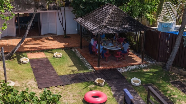 A backyard with a wooden deck, a gazebo, and a dining area with people. - 17th Century Sugar Mill Near Beach - Mullins Mill (Mullins)
