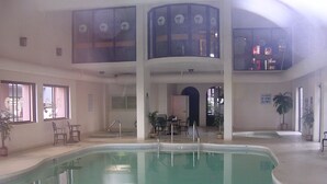 Ein großes Hallenbad mit Sitzgelegenheit und einem kleinen Tisch.