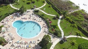 An aerial view of a resort with a large heart-shaped pool surrounded by sun loungers and palm trees. - Beautiful Marco Island Renovated Condo, 2 Br 2 Ba, 1704 T4,  Beach & Ocean Views (Marco Island)