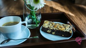 A tray with a cup of coffee and a slice of cake on a wooden table. - A SPACIOUS AND LUXURIOUS APARTMENT W/ 3 BEDROOM (Cebu City)