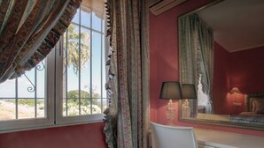 Una habitación con una cama, un escritorio con un espejo y una silla.