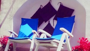 Two white lounge chairs with blue cushions in front of a wall with the text "Oltre Corso Bed & Breakfast". - B&b Oltre l'Arco (Molfetta)