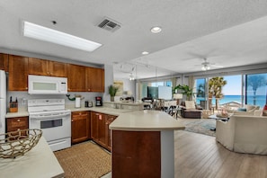 Una cocina moderna con gabinetes de madera, electrodomésticos blancos y una isla grande.