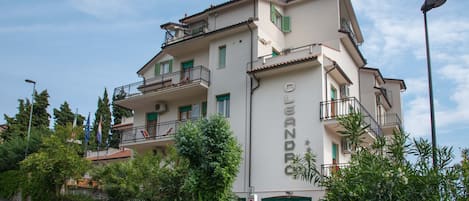Un edificio de varios pisos con balcones, un letrero que dice