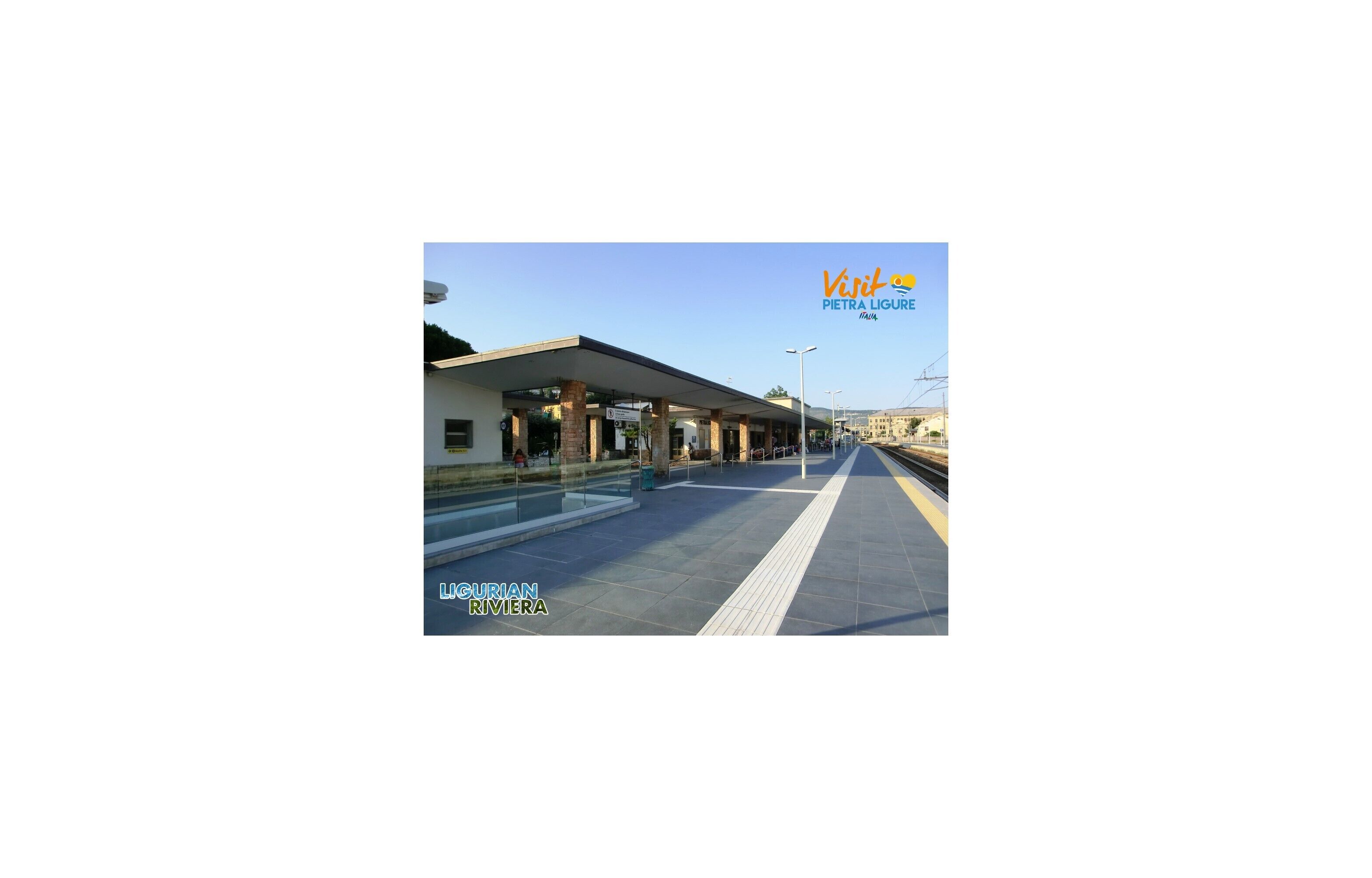 A train station platform with a covered waiting area and a clear sky.