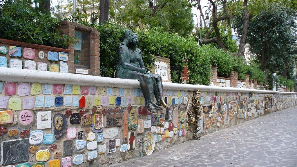 A wall with a statue and colorful nameplates.