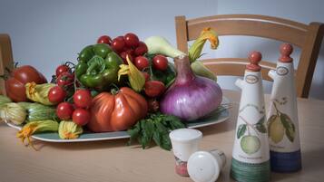 Een tafel met diverse groenten en twee zoutstrooiers.