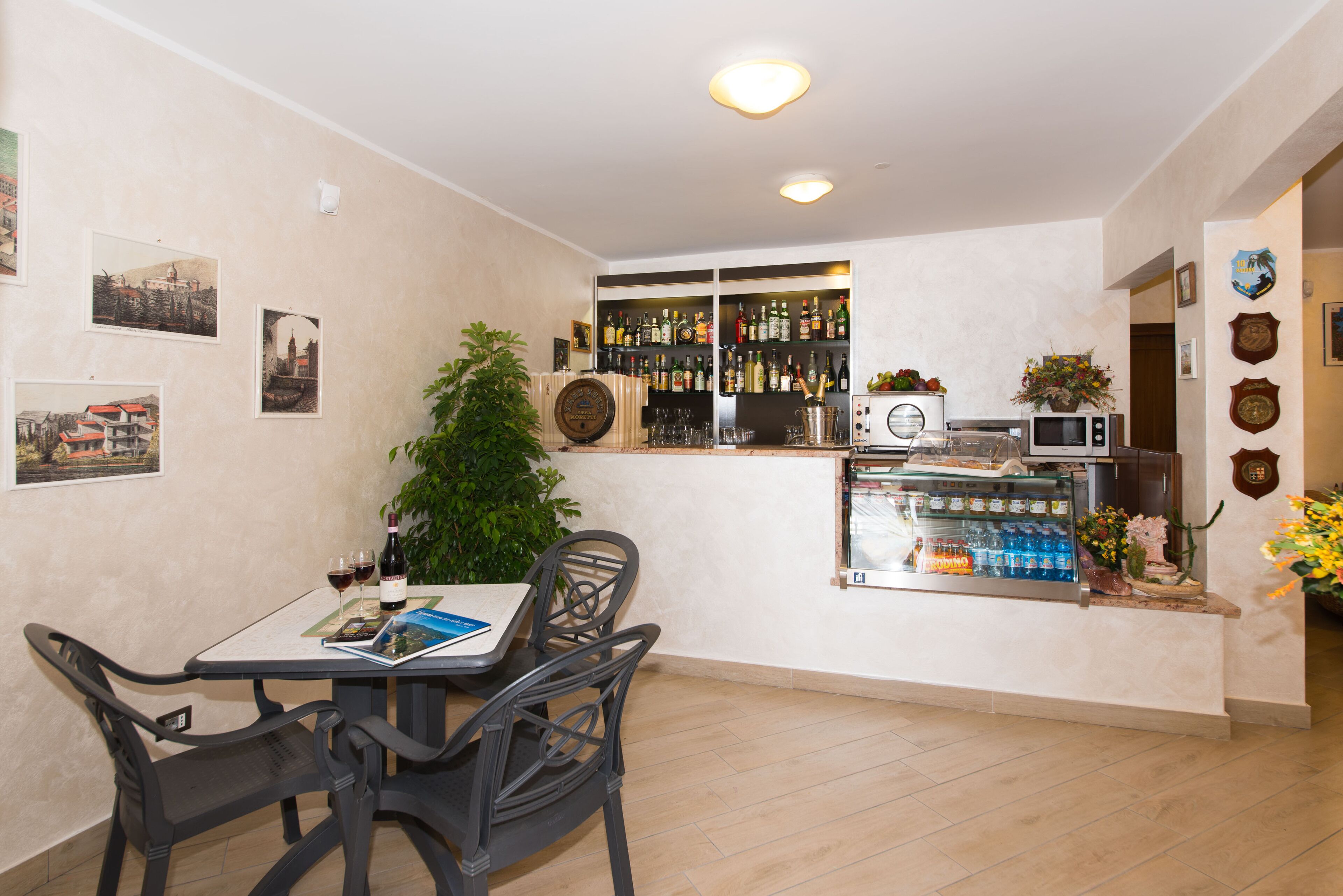 A dining area with a table, chairs, and a bar counter with various bottles and glasses.