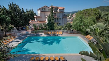 Una piscina al aire libre de temporada, sombrillas