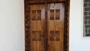 A wooden door with intricate carvings and a metal handle. - Salhiya Lodge - Hostel (Bububu)