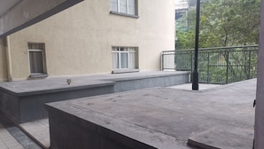 Un espacio exterior de concreto con escalones que conducen a un edificio con ventanas.