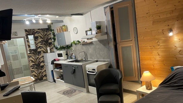 Une chambre d’hôtel compacte comprenant un coin cuisine, un espace repas et un lit.