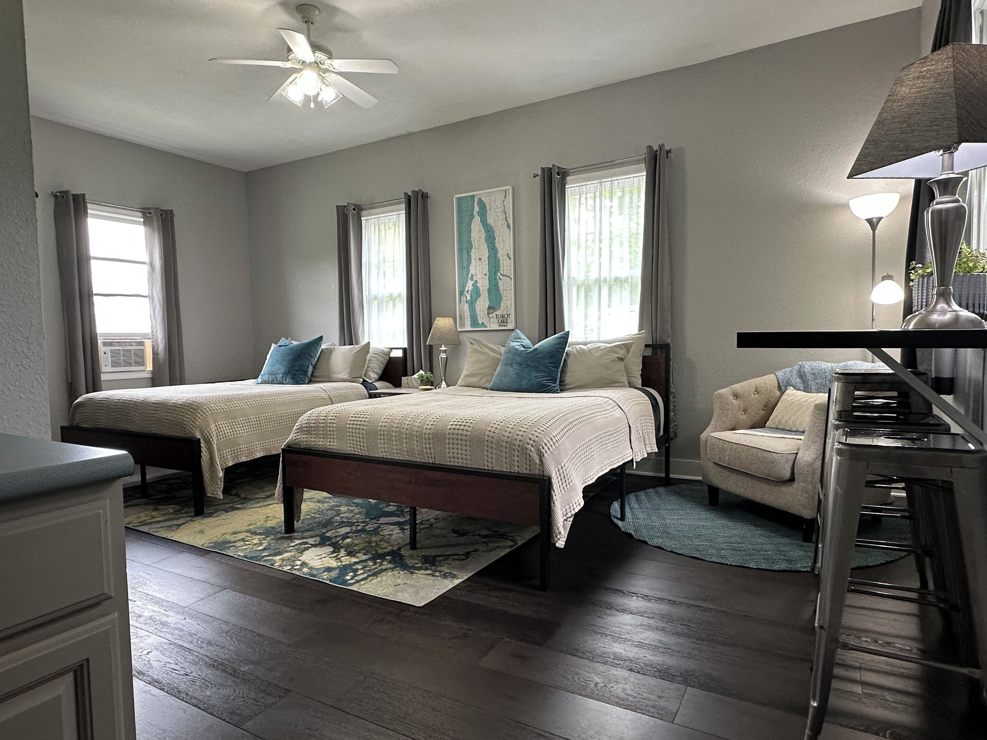A bedroom with two beds, a desk, and a chair.
