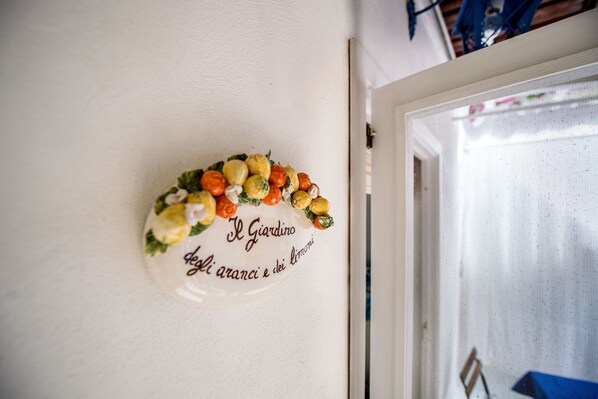 Un plato decorativo colgado en la pared con un arreglo floral y texto.