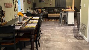 A cozy dining area with a long wooden table, chairs, and a decorative centerpiece. - Roscoe Cottage Pet Friendly  (Roscoe)