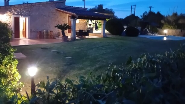 A stone house with a patio, outdoor seating, and a swimming pool. - QUIET FINCA CAN XAVI (Alcudia)