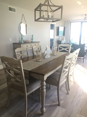 A dining area with a wooden table, chairs, and a chandelier.