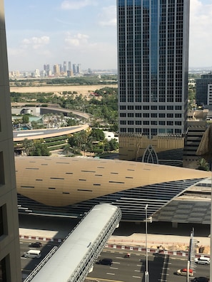 A modern building with a unique roof design, surrounded by a cityscape and a desert landscape. - Heartland Hostel (Dubai)