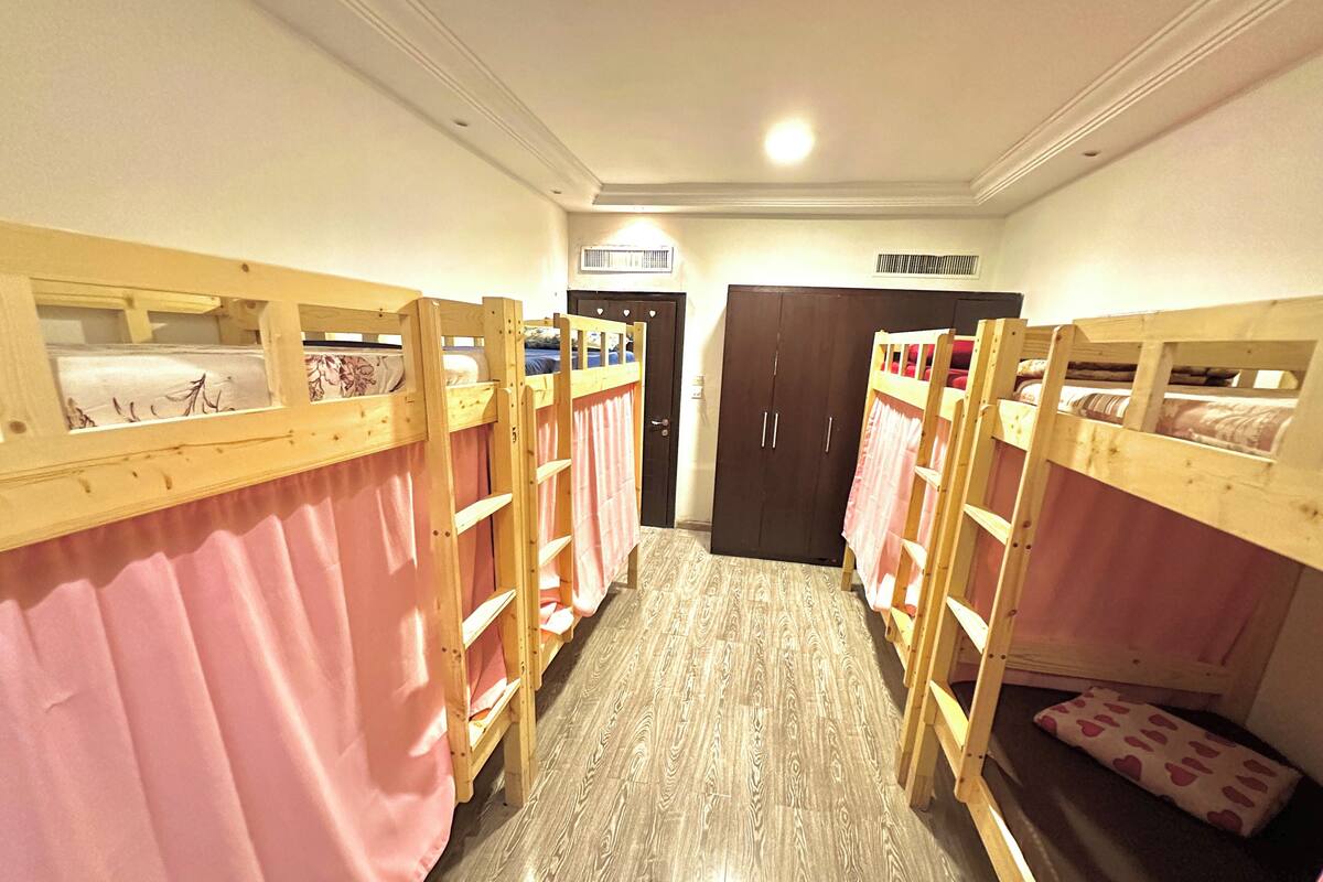 Ein Zimmer mit Etagenbetten, einem Kleiderschrank und einer Deckenleuchte.
