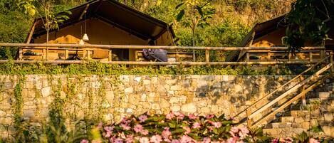 Un rustico chalet in legno con una parete in pietra e una scala di legno che vi conduce.