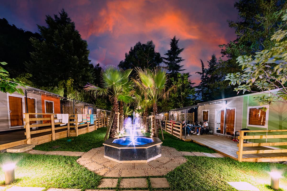 Une cour intérieure dotée d’une fontaine centrale, d’une terrasse en bois et de petits chalets aménagés comme des spas.
