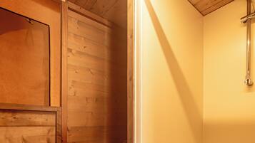 Un baño de madera con inodoro y ducha.