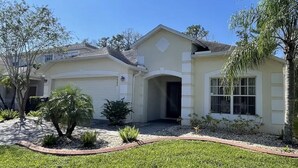 A single-story house with a garage, a front entrance, and a small front yard with landscaping.