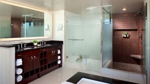 A modern bathroom with a glass-enclosed shower, a large mirror, and dark wooden cabinets. - Perfect for Conferencing, Shopping, Dining, Shows and the Strip! (Las Vegas)