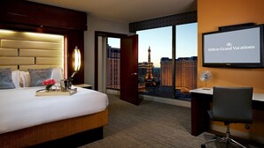 A hotel room with a bed, a desk, a chair, and a TV displaying 'Hilton Grand Vacations'. - Perfect for Conferencing, Shopping, Dining, Shows and the Strip! (Las Vegas)