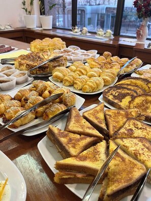 Une table de buffet proposant divers types de pâtisseries et de sandwichs.