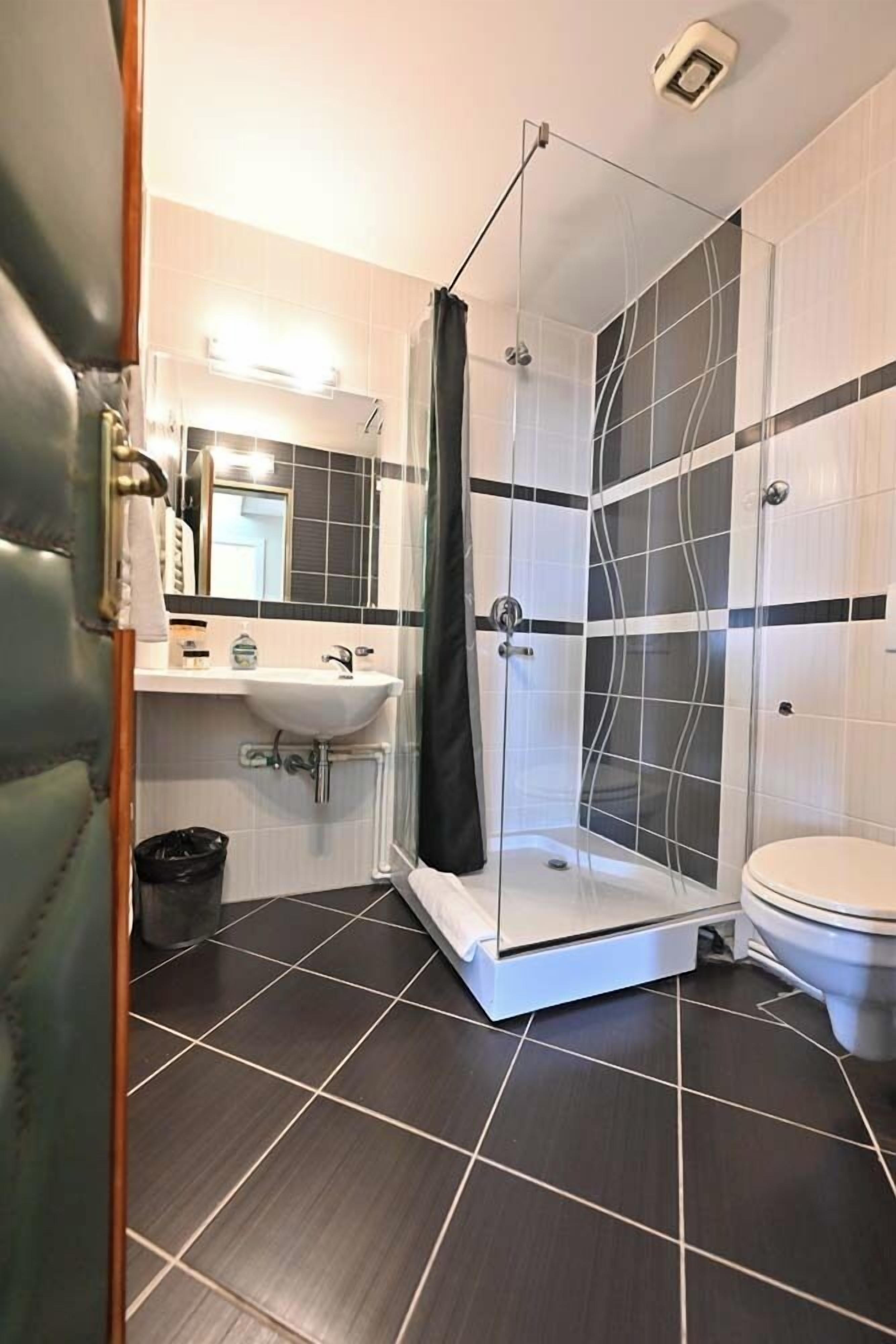 Une salle de bain avec une douche à parois de verre, un lavabo et des toilettes.