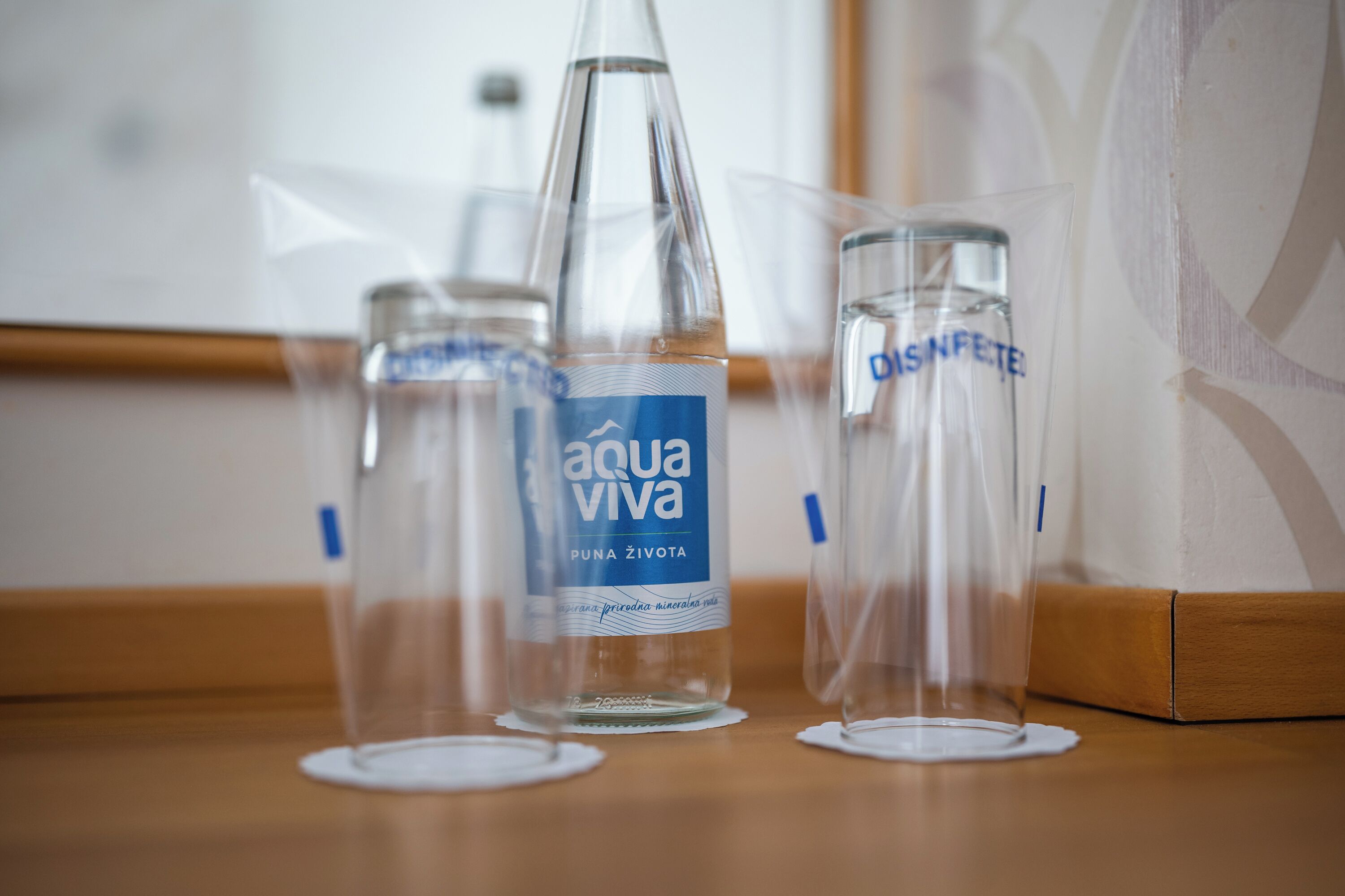 Three clear glass bottles with labels on a wooden surface.