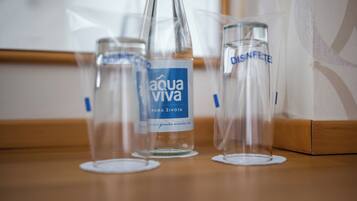 Three clear glass bottles with labels on a wooden surface.