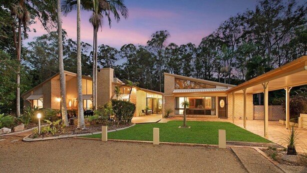 A modern two-story house with a covered patio and a well-maintained lawn. - Serendipity Gardens! (Joyner)