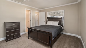 A bedroom with a bed, dresser, and a ceiling fan. - Grill, Relax, or Play at Home Away From Home (Shreveport)