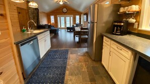 A spacious kitchen with wooden cabinets, a dishwasher, a coffee maker, and a dining area with a table and chairs. - Newly Renovated AC 4 ACRES 3000sqft home with Full Game Room (Hunter)
