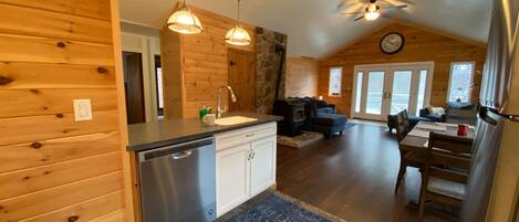 A cozy cabin interior with a kitchen, dining area, and living room.