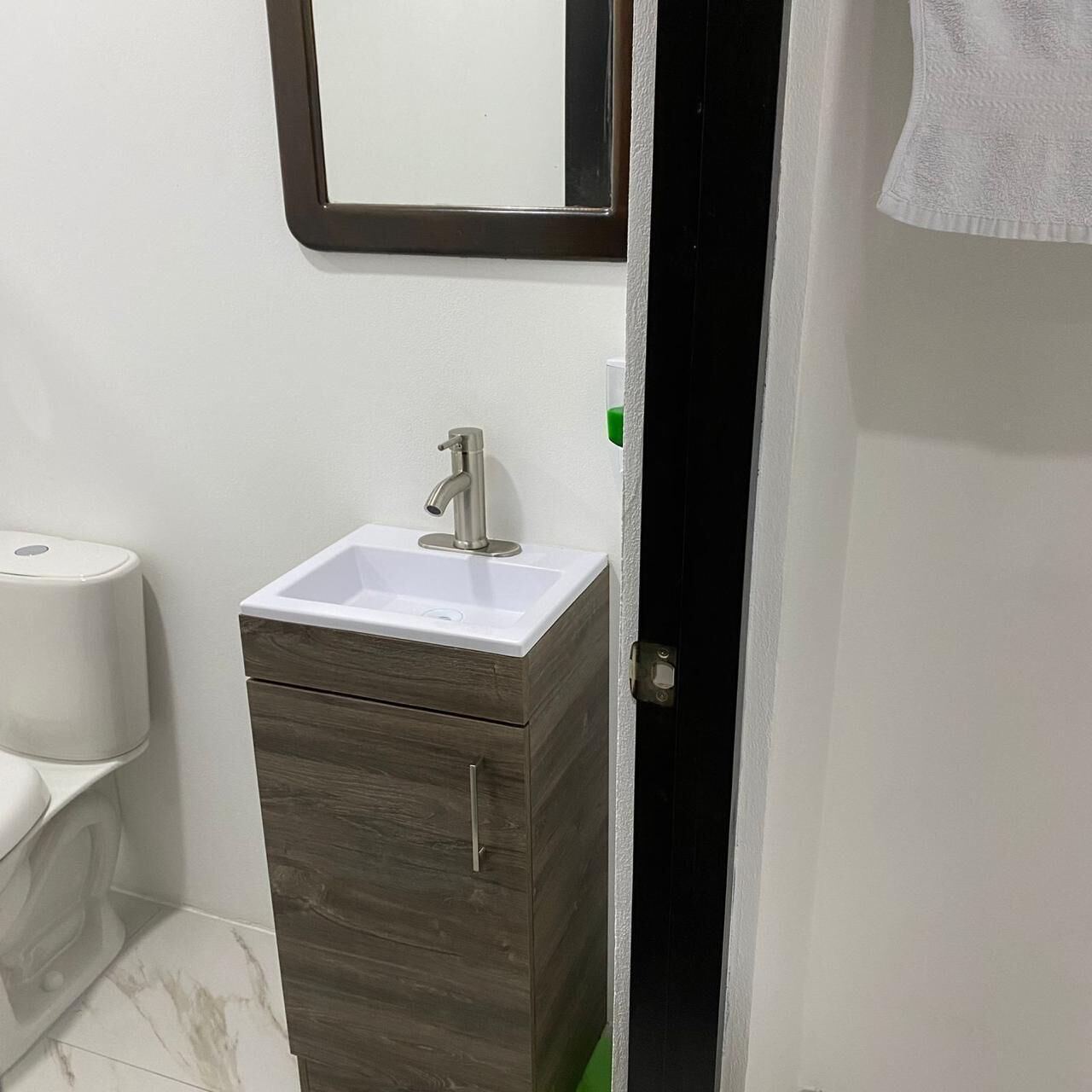 A bathroom with a white sink, a mirror, and a wooden cabinet.