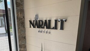 A sign for Naraliit Hotel with a potted plant in front. - Hotel Naralit (Tilaran)