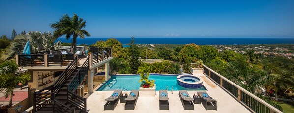 A rooftop pool area with lounge chairs, a hot tub, and a view of the ocean. - An Ultra-Luxurious Resort Style Ocean View Villa. Optional Yacht, Fully Staffed! (Discovery Bay)