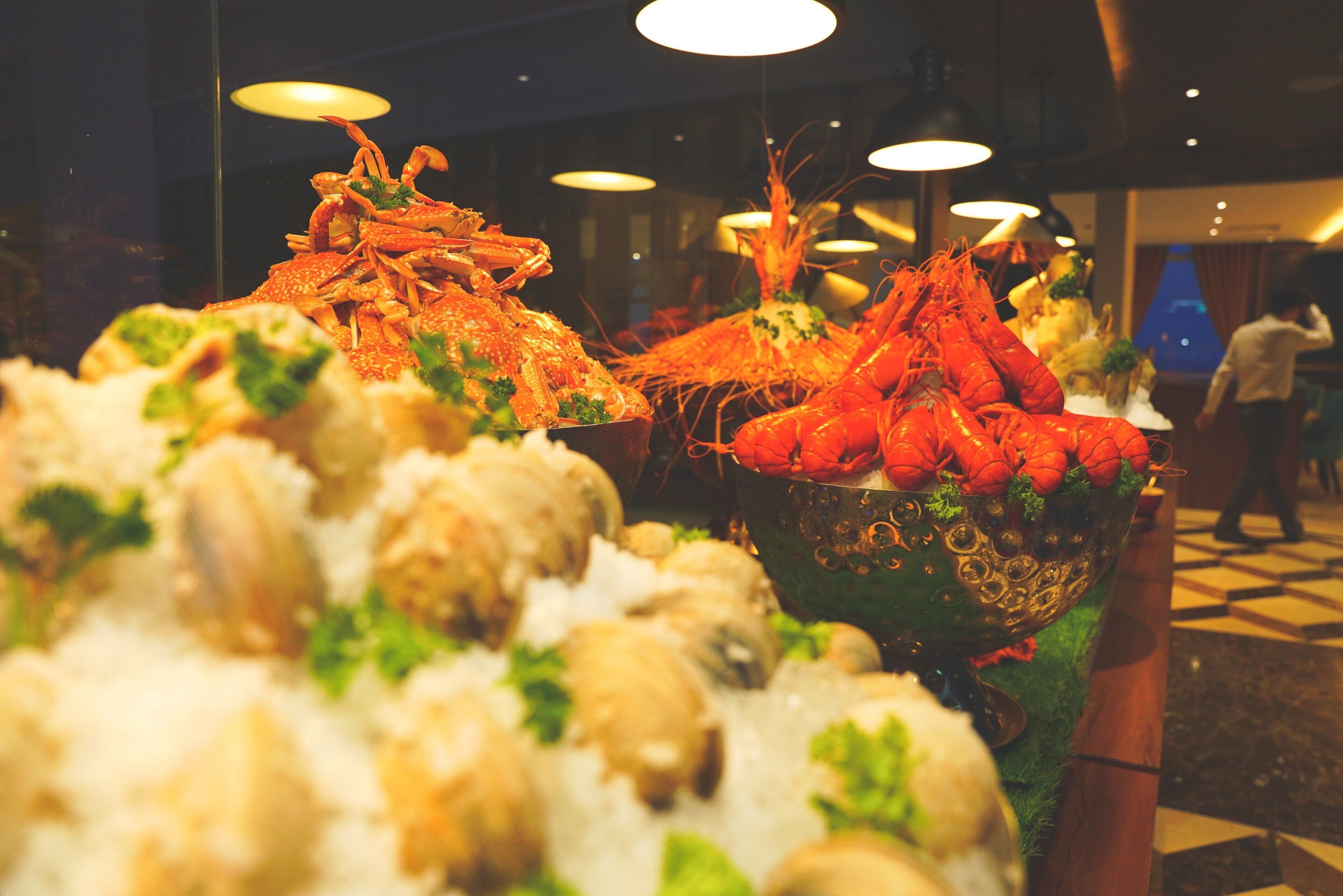 A seafood display with various types of seafood, including lobsters and shrimp, arranged on a bed of ice.