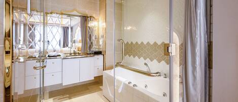 A modern bathroom with a glass-enclosed shower, a large bathtub, and a vanity with a mirror and countertop.