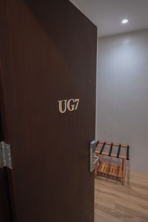 Una puerta de madera con un picaporte de metal y las letras "UG7".
