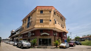 A multi-story building with a curved facade, multiple balconies, and parked cars in front. - Hotel O Hotel Oriental (Kota Kinabalu)