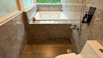Un baño con bañera, ducha e inodoro.