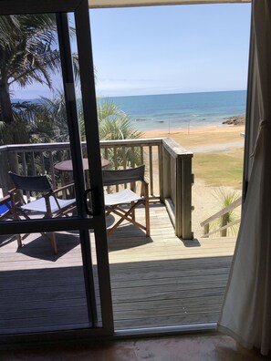 A wooden deck with a view of the beach and ocean. - Driftwood Lodge (Cable Bay)