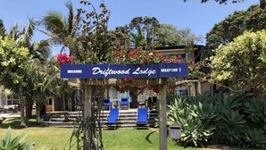 Señal de Driftwood Lodge, con una zona de recepción visible al fondo.